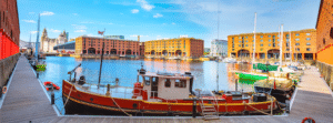 Royal Albert Dock with orange buildings and a red boat