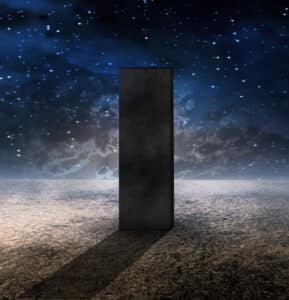 Strange monolith on lifeless planet amongst stars and dark blue sky